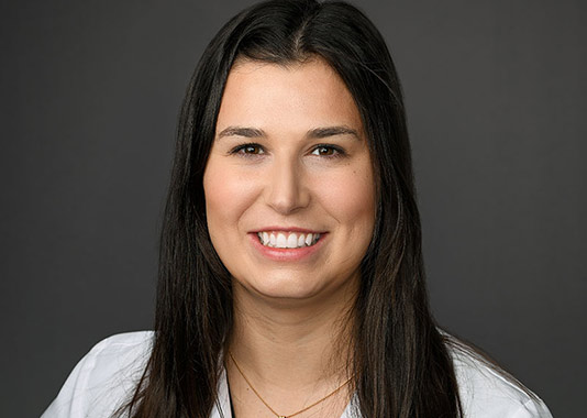 Professional headshot of orthopedic physician assistant Samantha Hutchins, PA-C, smiling in white lab coat.