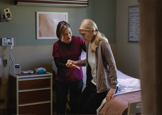 A physical therapy specialist assists an elderly blonde woman during post-surgery rehabilitation exercises at St. Peter's.