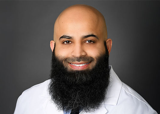 Professional headshot of orthopedic surgeon Dr. Hamza Murtaza, MD, smiling in white lab coat.